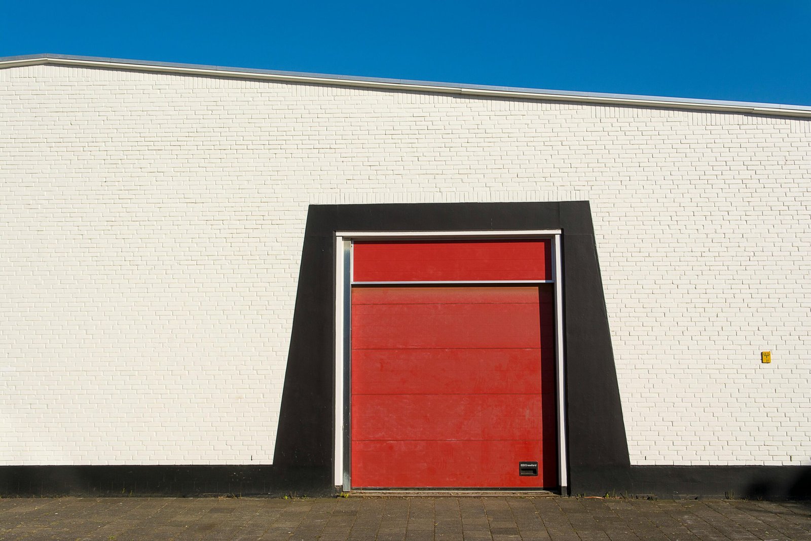 porte sectionnelle industrielle rouge installée à Namur